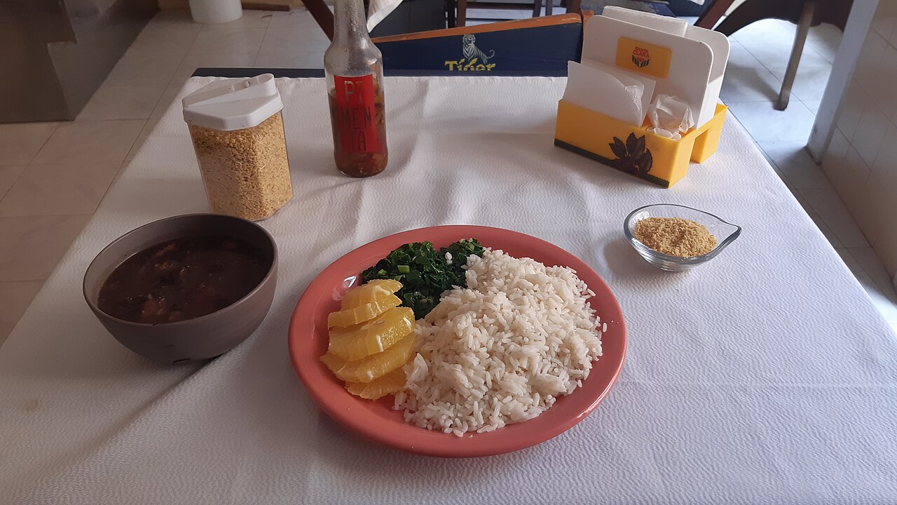Prato de feijoada com arroz, farofa e couve, visto de cima